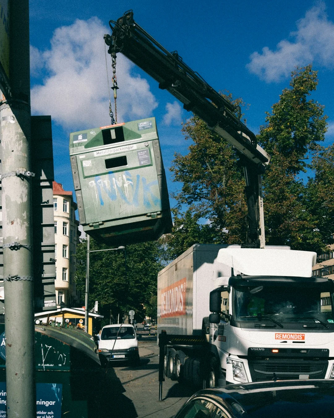 Une main essuie une surface foncée avec un mouchoir, près d’un rouleau de papier et d’une plante.